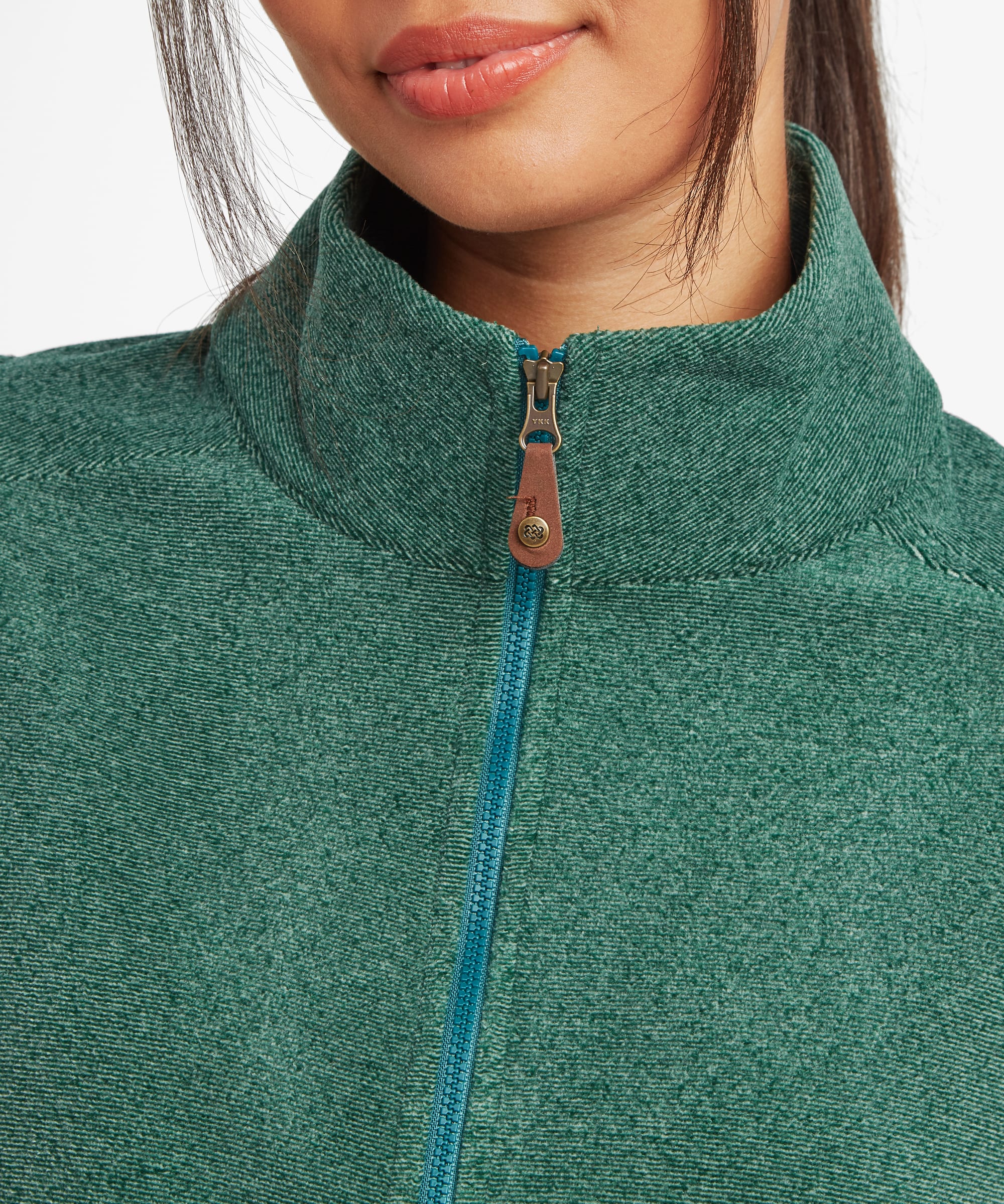 Close-up detail of the deep green fleece vest showing the high stand collar, front zip closure, and soft textured fleece fabric around the neckline and chest.