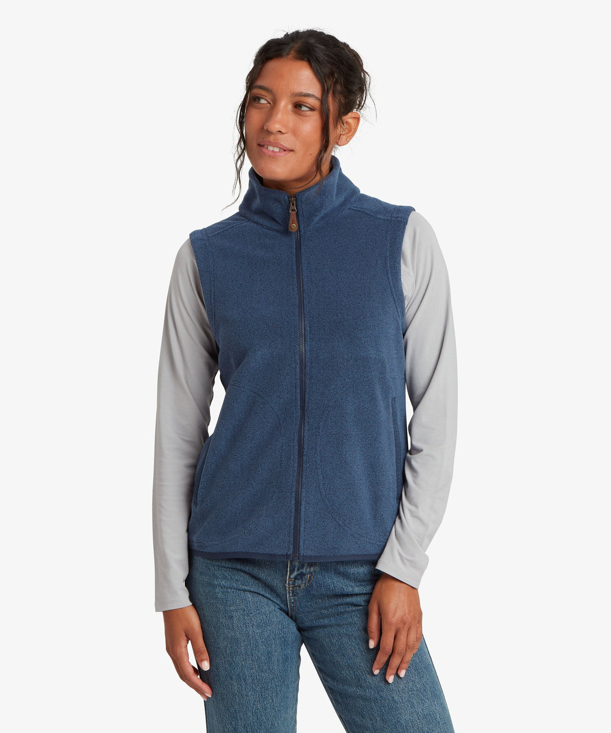 A woman modeling a sleeveless zip-front fleece vest in heathered blue.