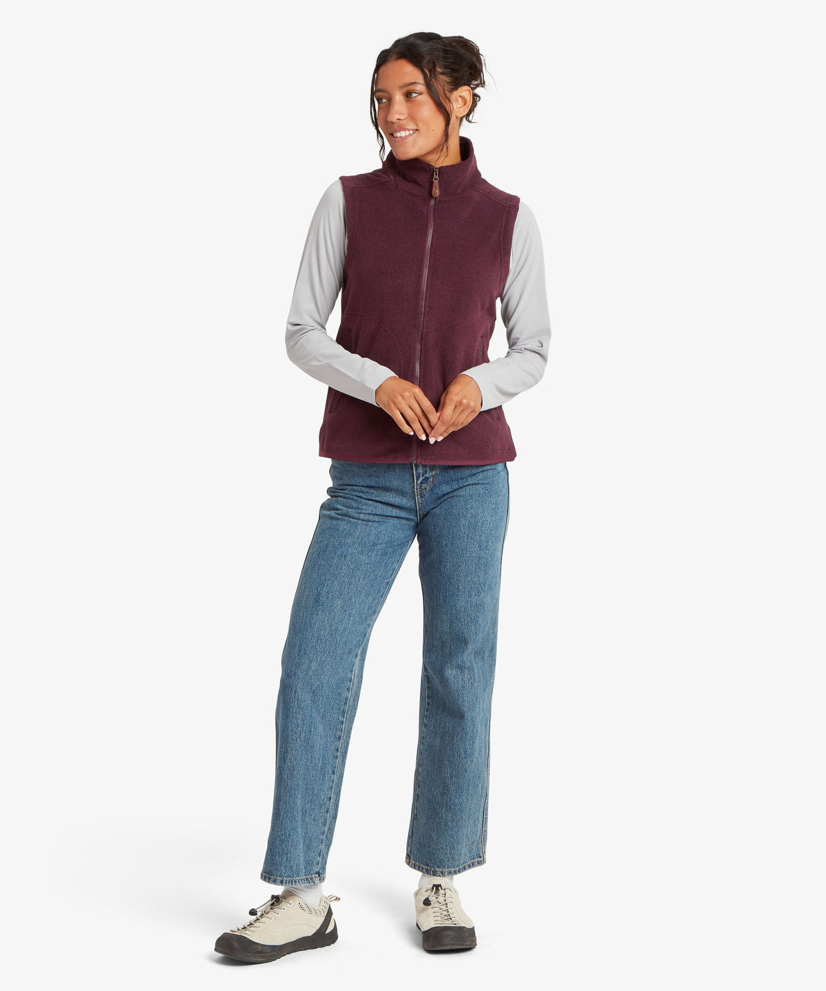 A woman modeling a sleeveless zip-front fleece vest in deep burgundy.