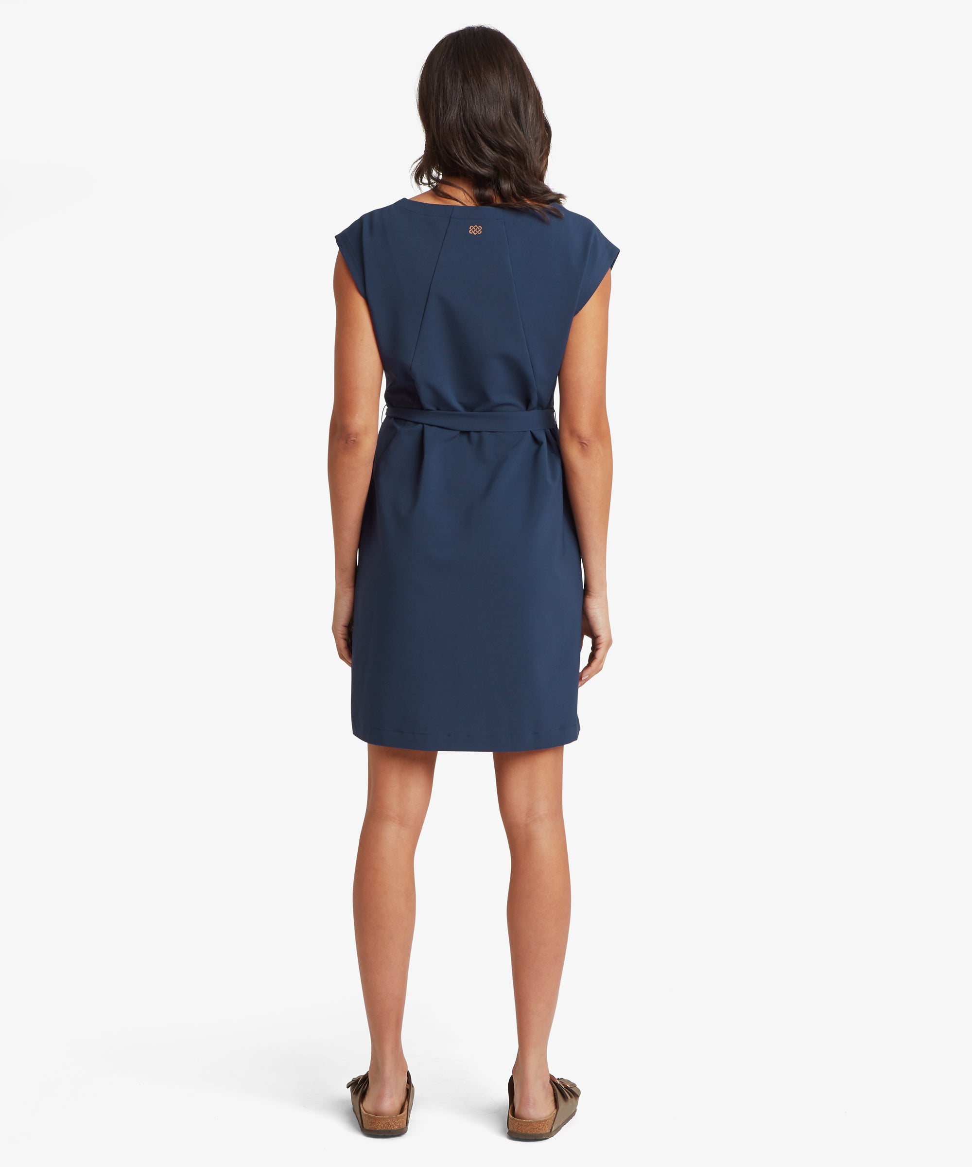 Back view of a woman wearing a navy sleeveless dress with a defined waist created by a tie belt. The dress falls to the knee with a straight, easy shape and a smooth back panel.