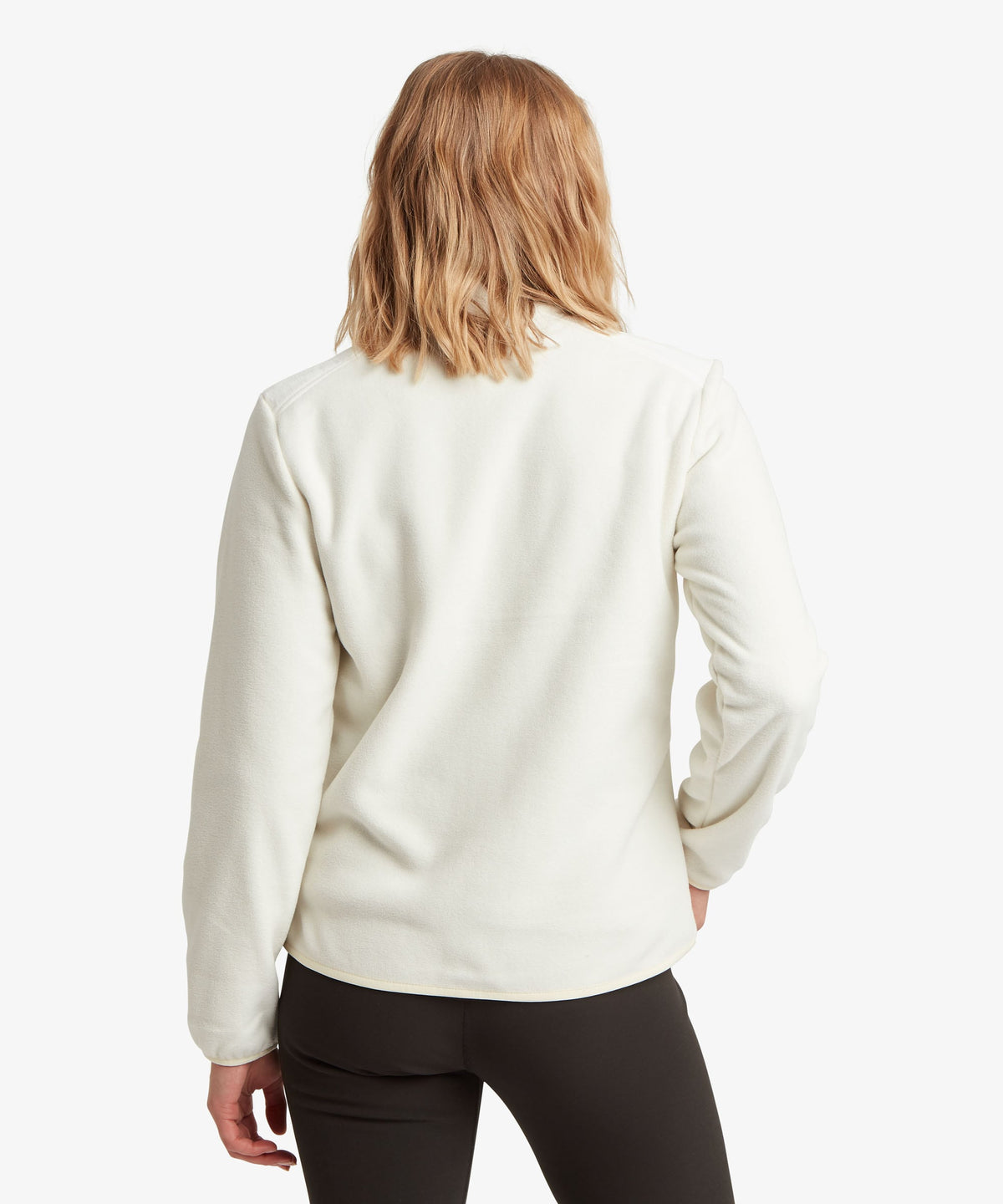 A female model wearing the Sherpa Adventure Gear white Sanu Full-Zip fleece.