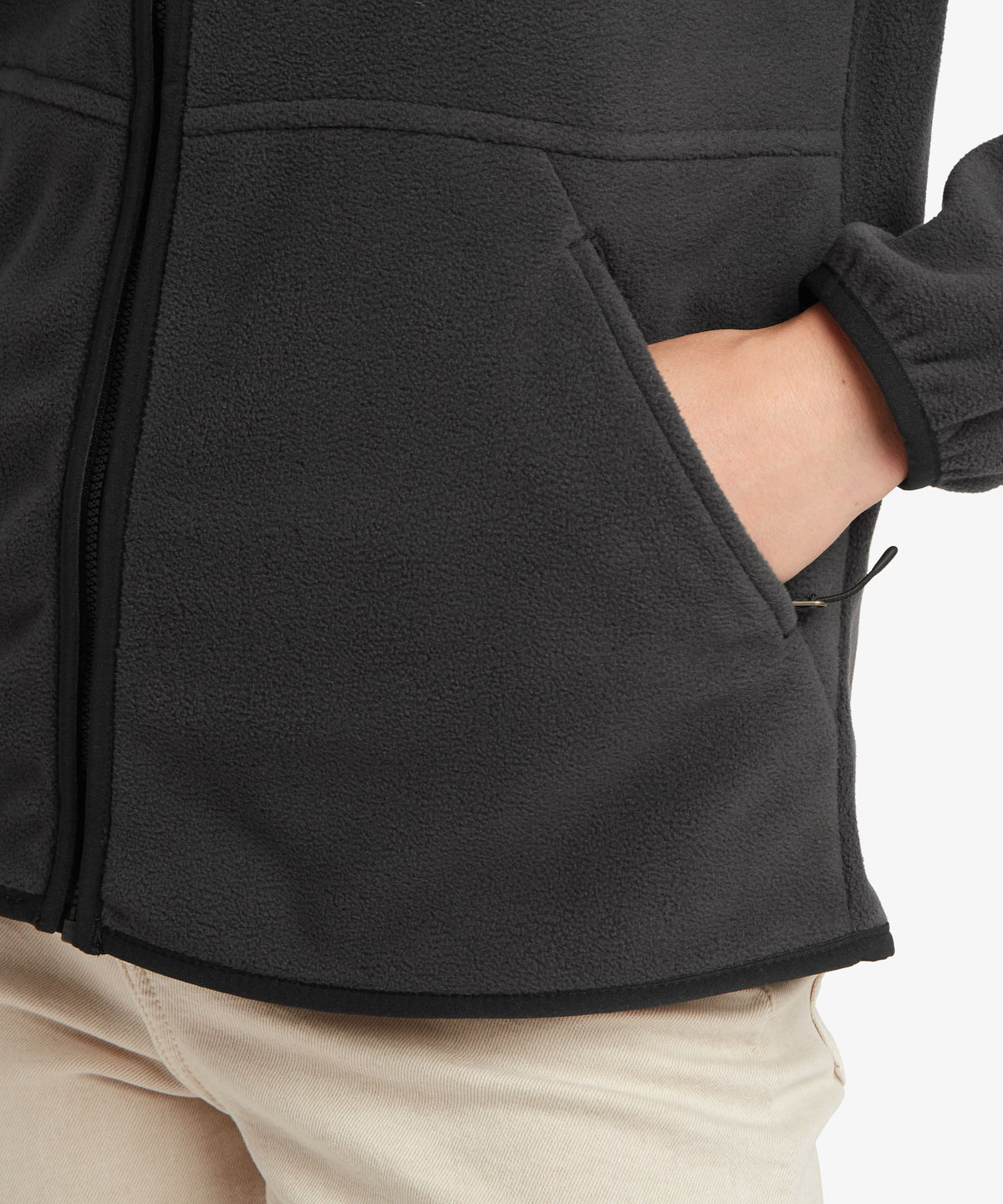 A female model wearing the Sherpa Adventure Gear black Sanu Full-Zip fleece, shown in close-up.