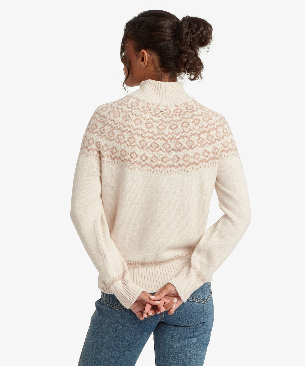 A woman viewed from behind wearing a cream-colored knit sweater with a dusty pink Fair Isle.