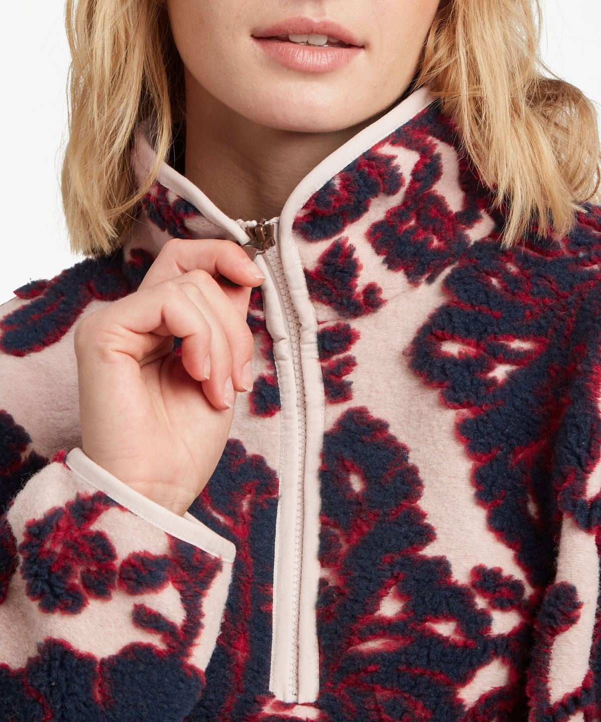 A female model wearing the Sherpa Adventure Gear women's Tara 1/4-zip fleece in beige.