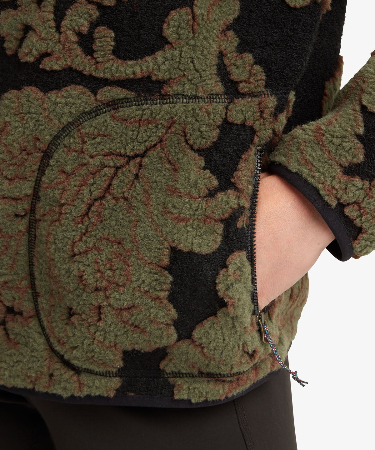 A female model wearing the Sherpa Adventure Gear women's Tara full-zip fleece jacket in green.