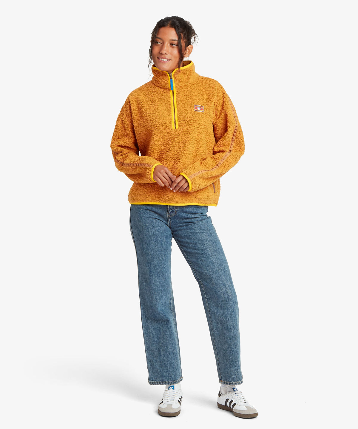 A woman modeling a textured mustard yellow quarter-zip fleece pullover with a bright yellow.