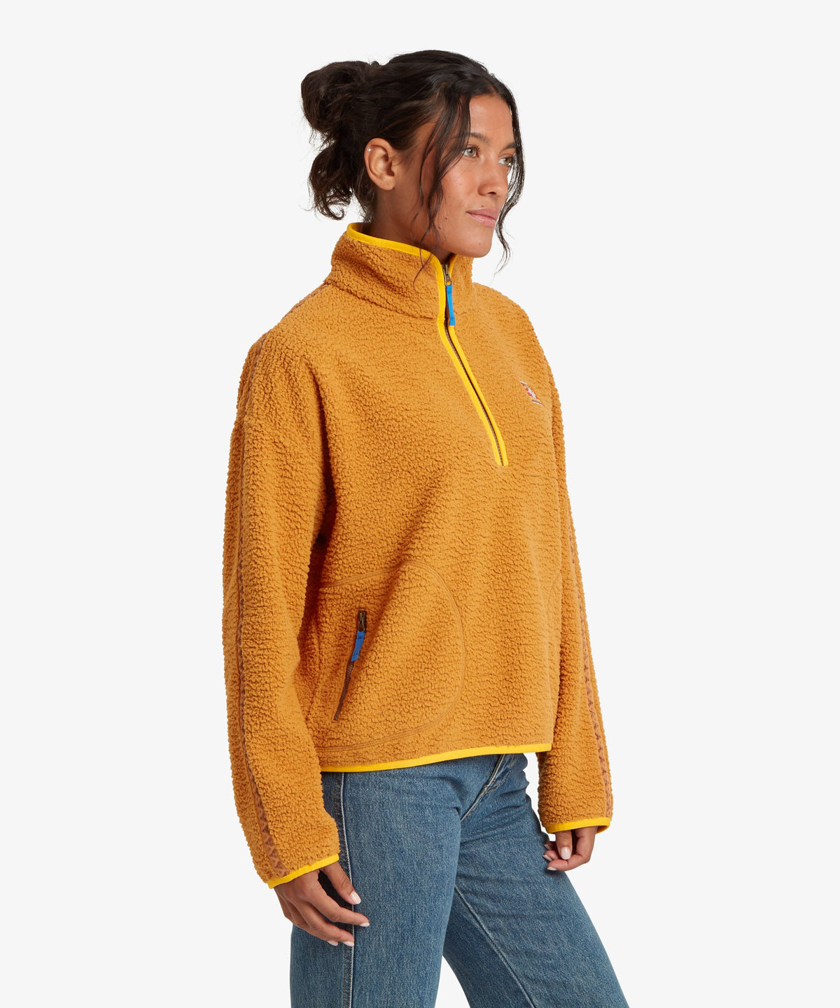 A woman wearing a golden yellow sherpa fleece quarter-zip pullover with bright yellow trim.