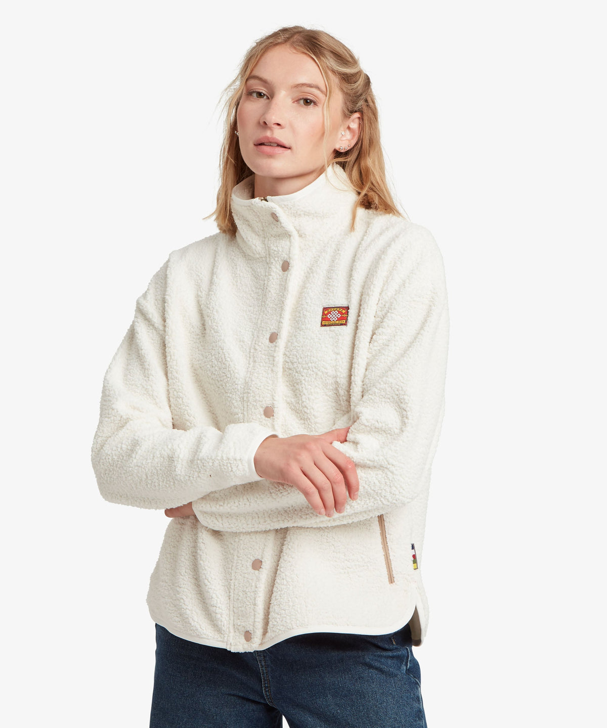A female model wearing the white Tarcho Full-Zip Jacket by Sherpa Adventure Gear.