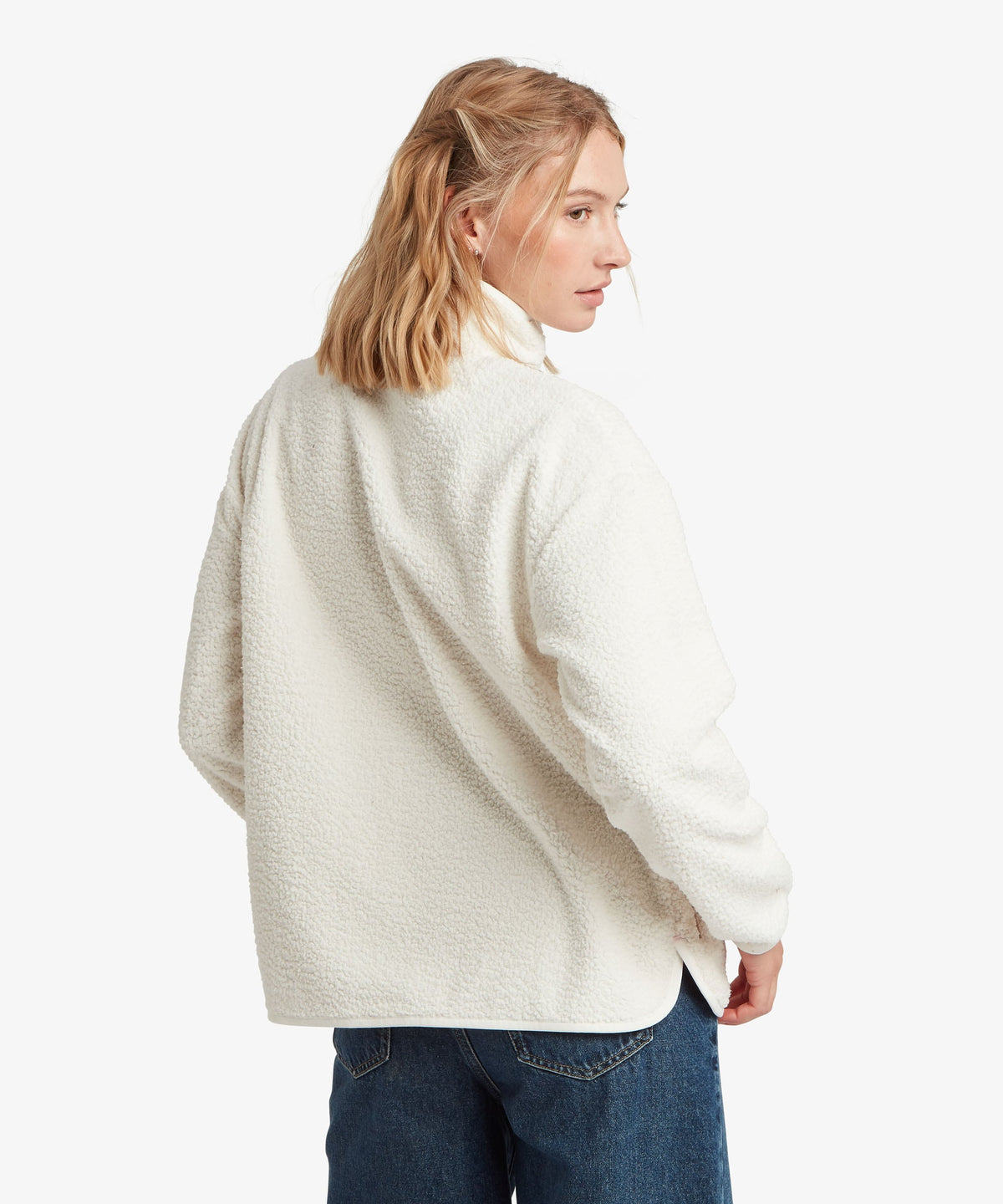 A female model, shown from the back, wearing the white Tarcho Full-Zip Jacket by Sherpa Adventure.