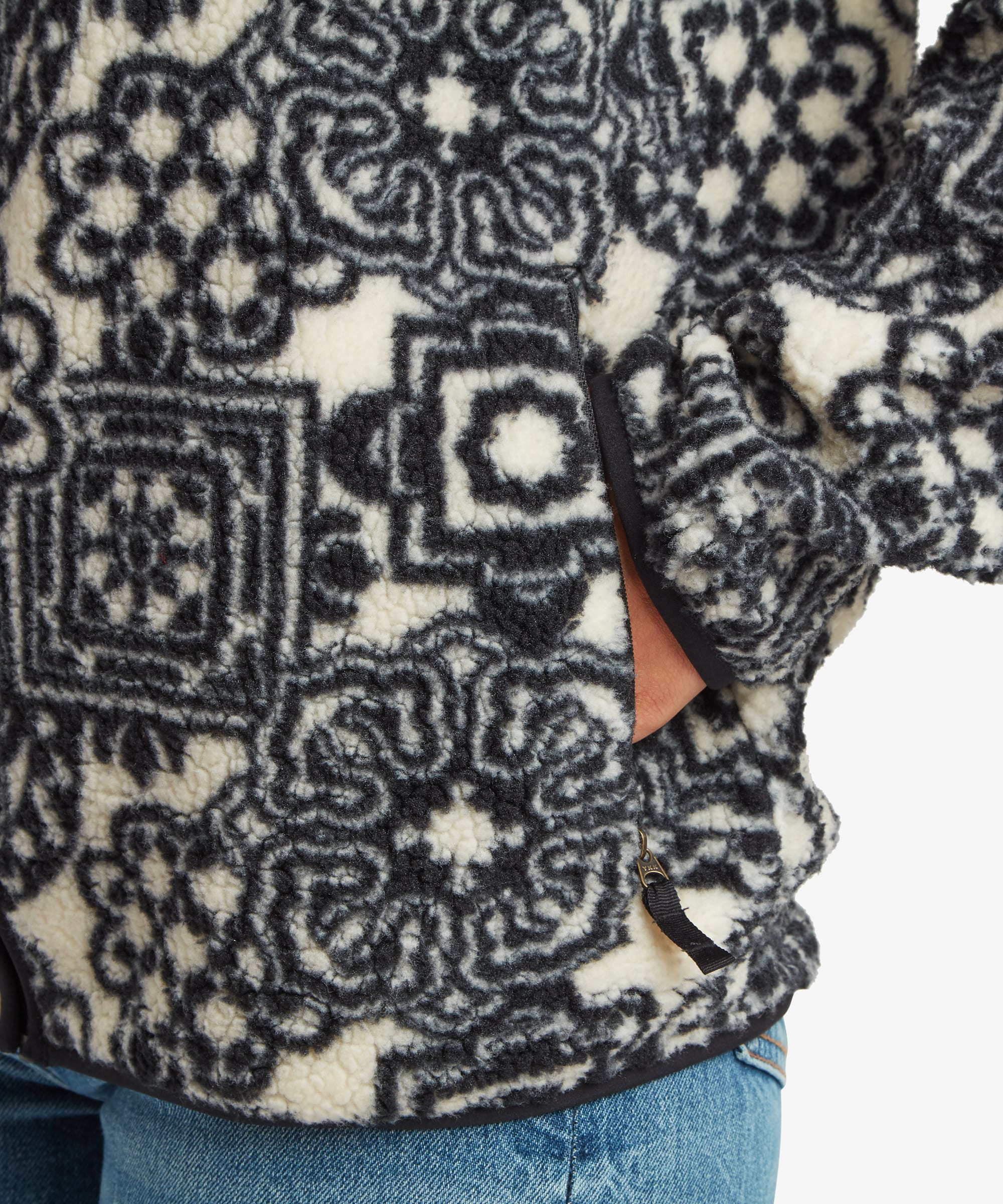 A colour up of  black full-zip fleece jacket featuring a intricate geometric patchwork-inspired print.
