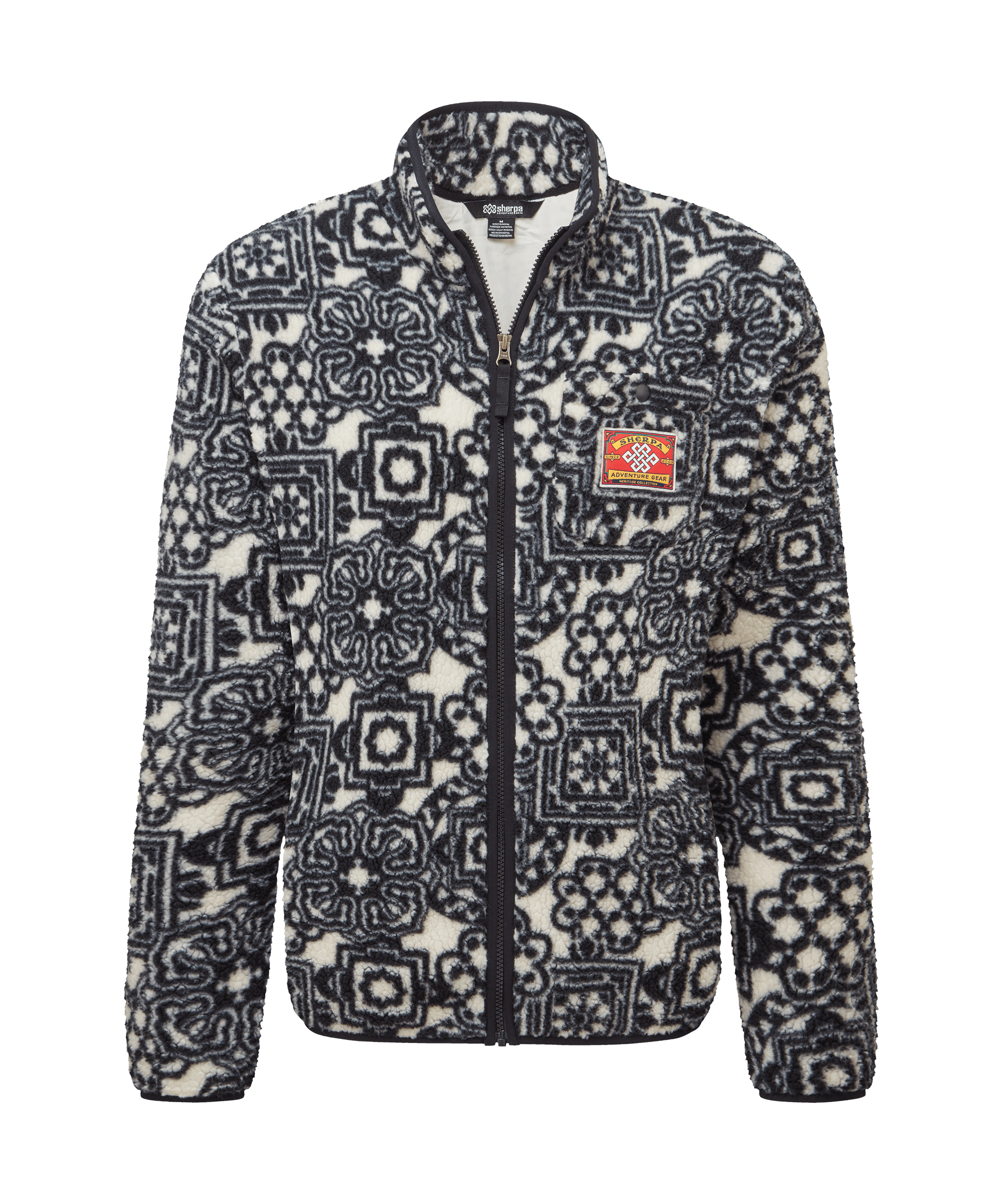 Front view of a women's Sherpa Adventure Gear printed full-zip fleece jacket in charcoal black and white. Features a stand collar, full-front zipper, and an allover snowflake-inspired geometric pattern for a distinctive winter-ready look.