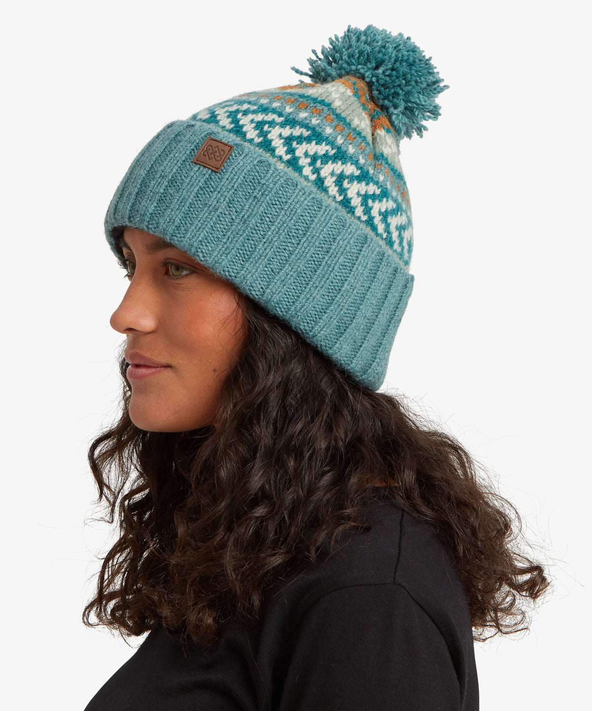 A woman in profile wearing a teal knit beanie.