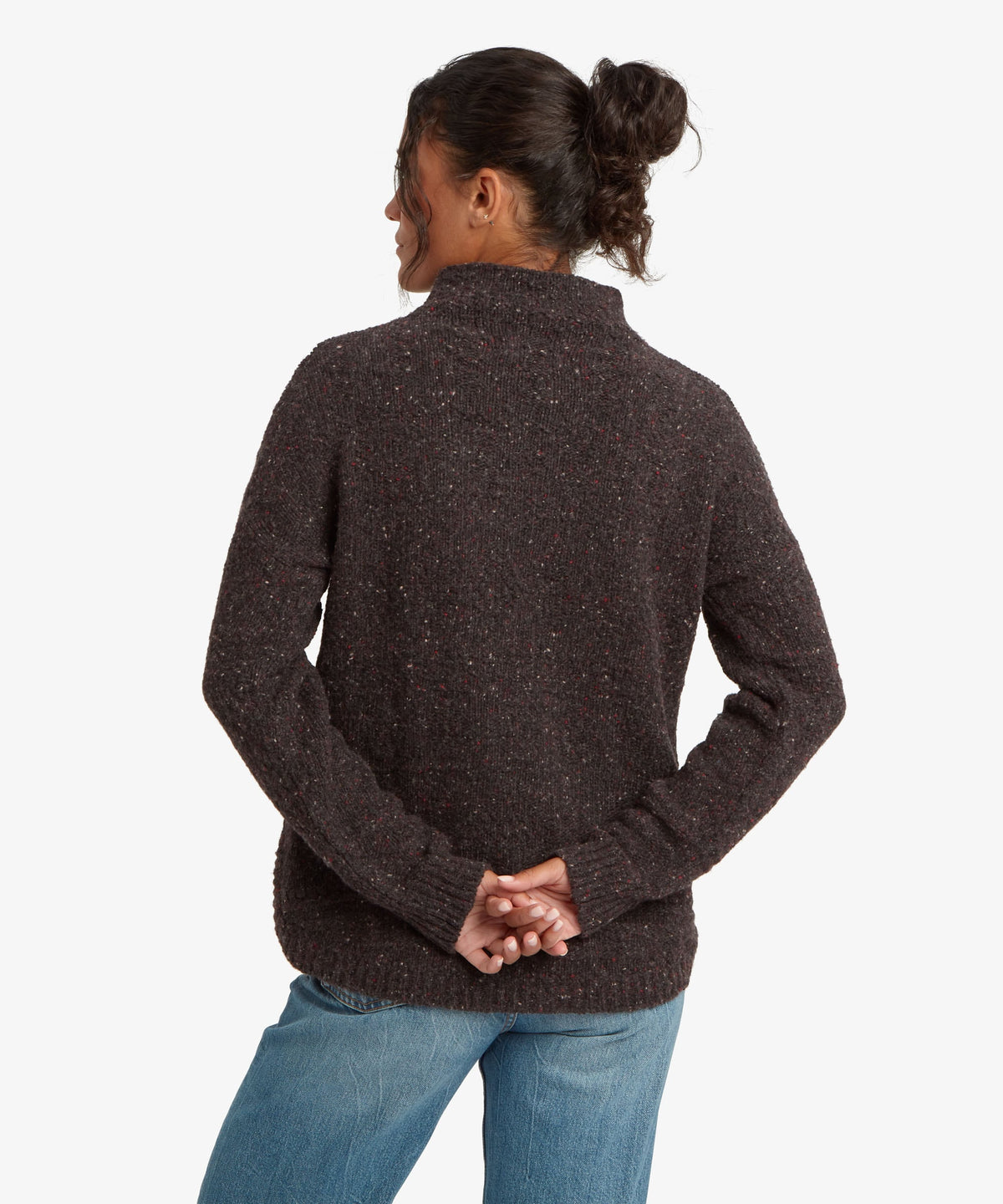 A female model, shown from the back, wearing the black Yuden Sweater by Sherpa Adventure Gear.