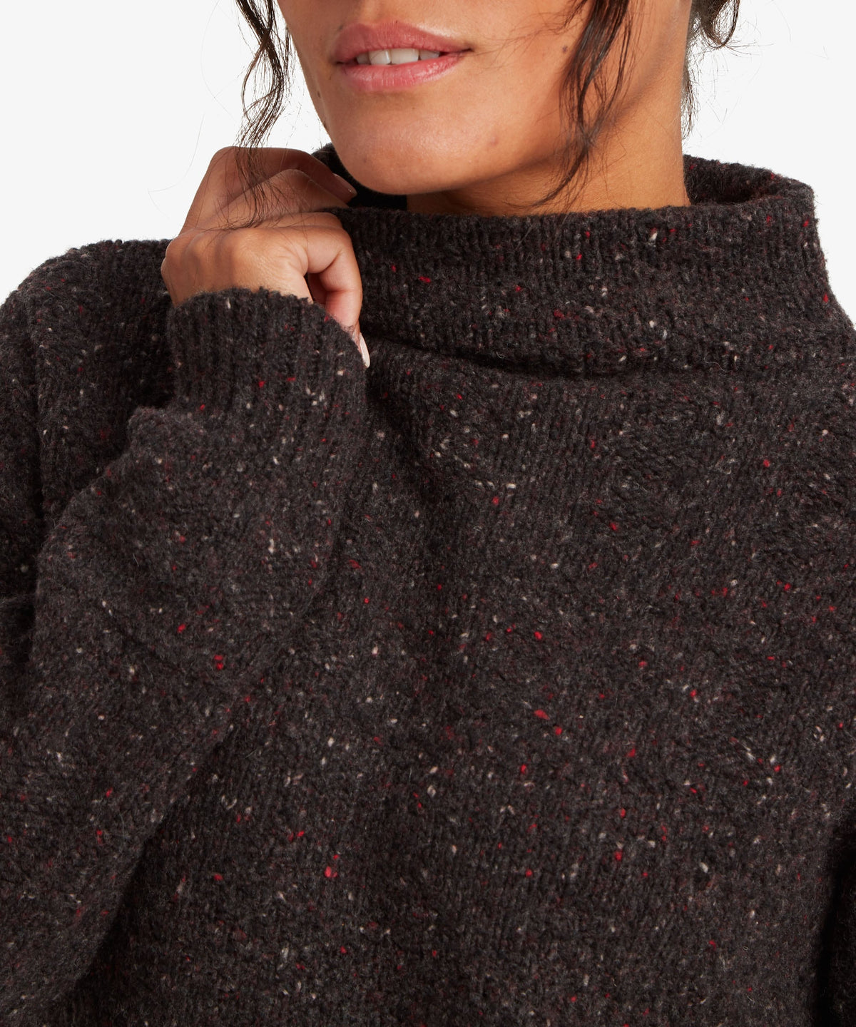 A female model wearing the black Yuden Sweater by Sherpa Adventure Gear, shown in close-up.