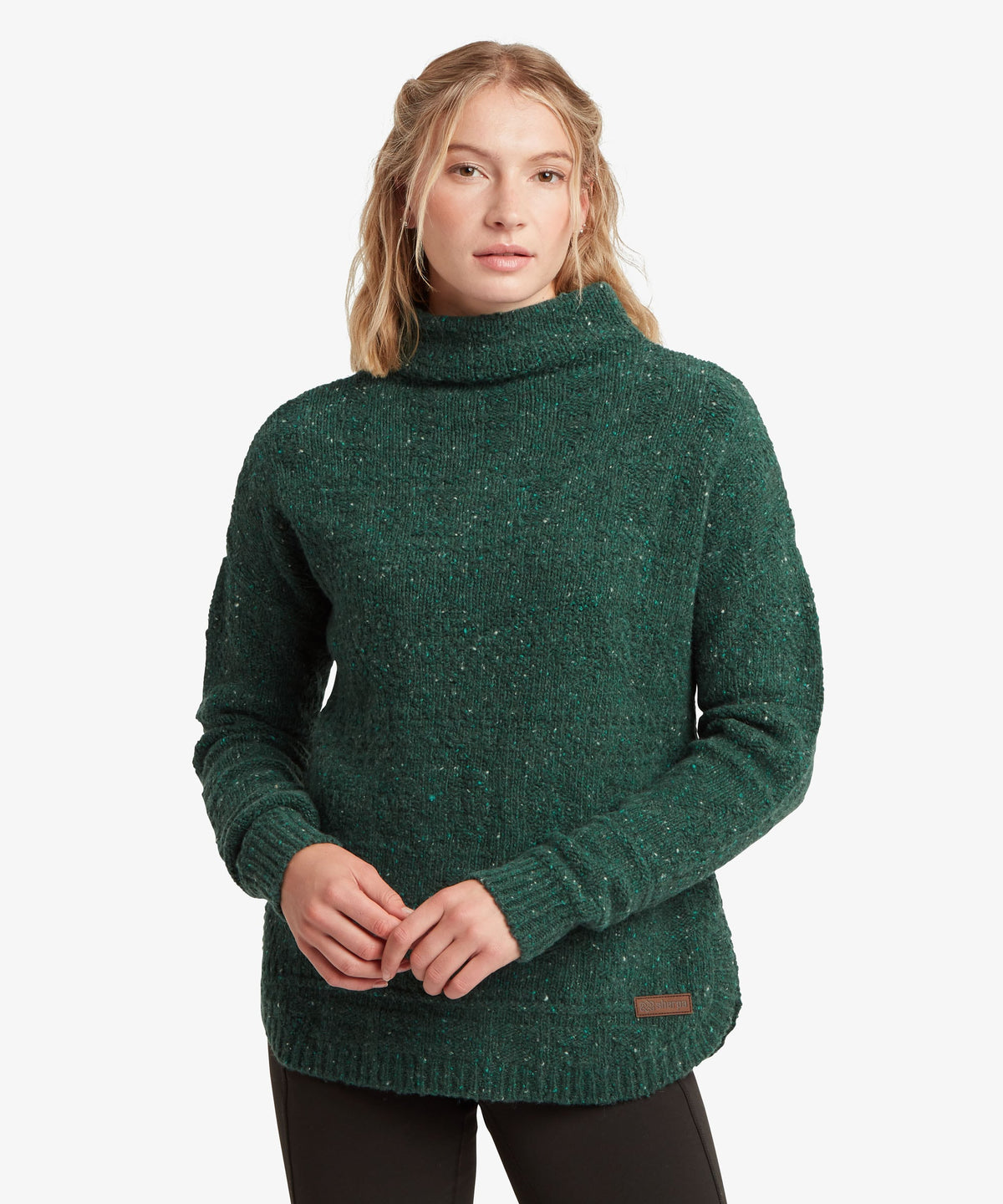 A female model wearing the green Yuden Sweater by Sherpa Adventure Gear.